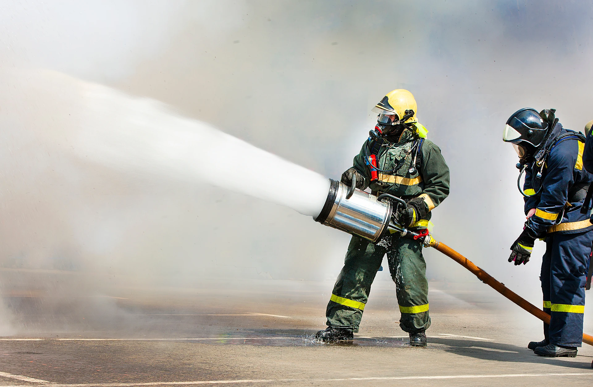 Firefighter spraying fire fighting foam